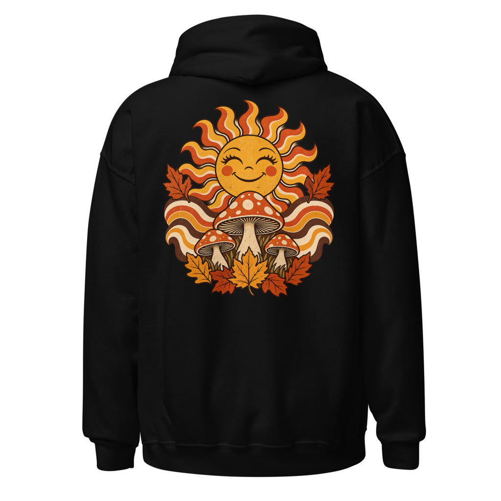 Lächelnde Sonne mit geschwungenen Strahlen, drei rot-weiß gepunktete Fliegenpilze und orange-braunes Herbstlaub vor welligem Hintergrund. – Unisex Heavy Blend Hoodie | Gildan 18500