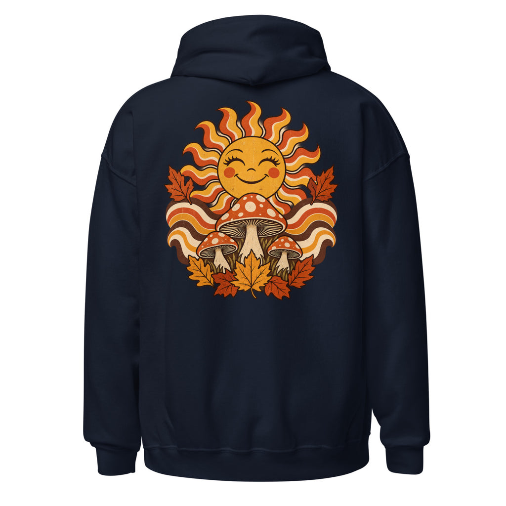 Lächelnde Sonne mit geschwungenen Strahlen, drei rot-weiß gepunktete Fliegenpilze und orange-braunes Herbstlaub vor welligem Hintergrund. – Unisex Heavy Blend Hoodie | Gildan 18500