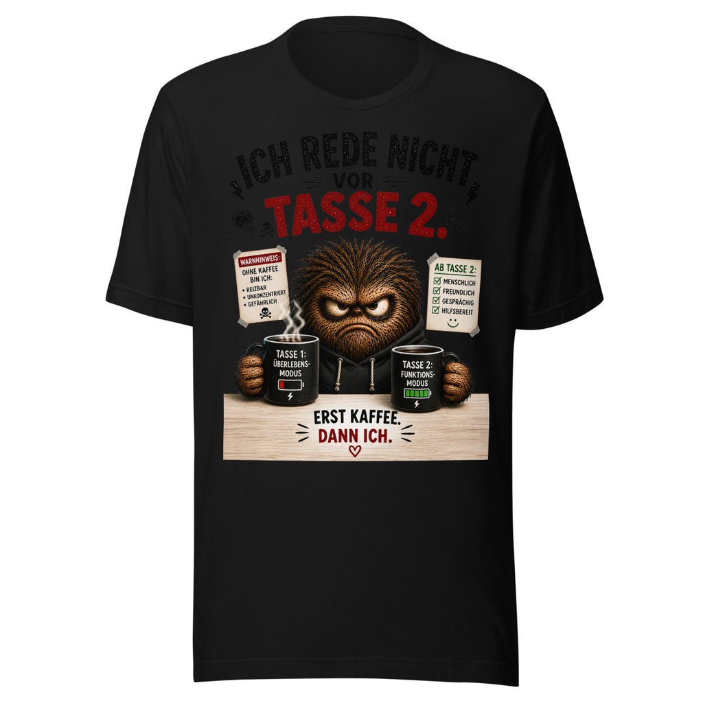 Unisex T-Shirt in Black, Vorderansicht mit Frontprint: Ein mürrisches, braunes, pelziges Monster mit Hoodie hält zwei schwarze Kaffeetassen. Auf der linken Tasse steht "Tasse 1: Überlebensmodus" mit niedrigem Batteriestand, auf der rechten "Tasse 2: Funktionsmodus" mit vollem Batteriestand. Text darüber: "Ich rede nicht vor Tasse 2." Text darunter: "Erst Kaffee. Dann ich." – Unisex Staple T-Shirt | Bella + Canvas 3001
