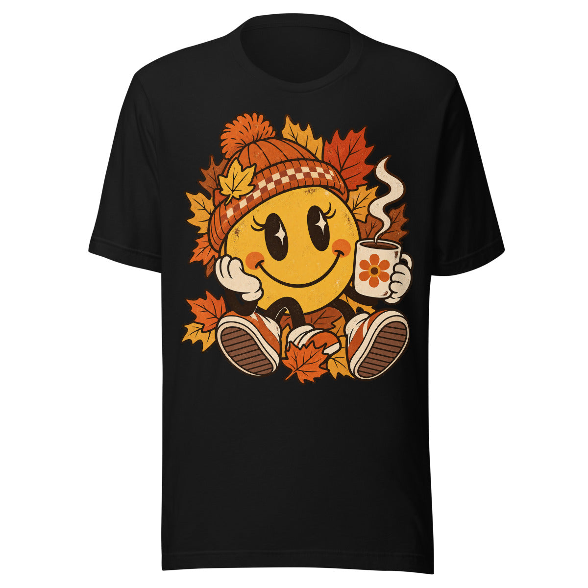 Lächelnder gelber Smiley mit großen glänzenden Augen, orange karierter Strickmütze und weißen Handschuhen sitzt umgeben von orange und gelb gefärbten Ahornblättern, hält eine dampfende Kaffeetasse mit Blumenmotiv in der rechten Hand. – Unisex Staple T-Shirt | Bella + Canvas 3001