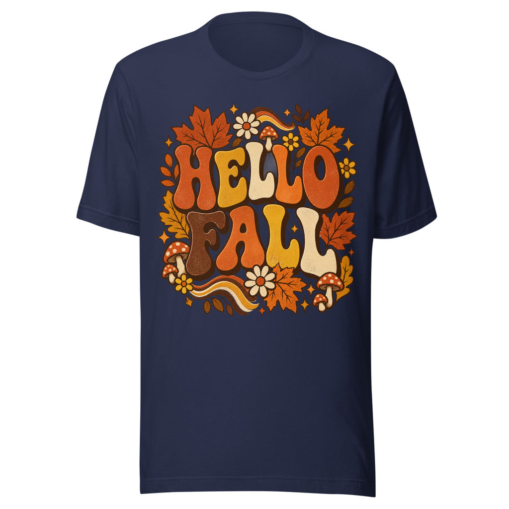 Schriftzug "HELLO FALL" in großen, bunten Buchstaben umgeben von orangefarbenen Ahornblättern, roten Fliegenpilzen mit weißen Punkten, gelben und weißen Blumen sowie dekorativen Sternen und Blättern. – Unisex Staple T-Shirt | Bella + Canvas 3001